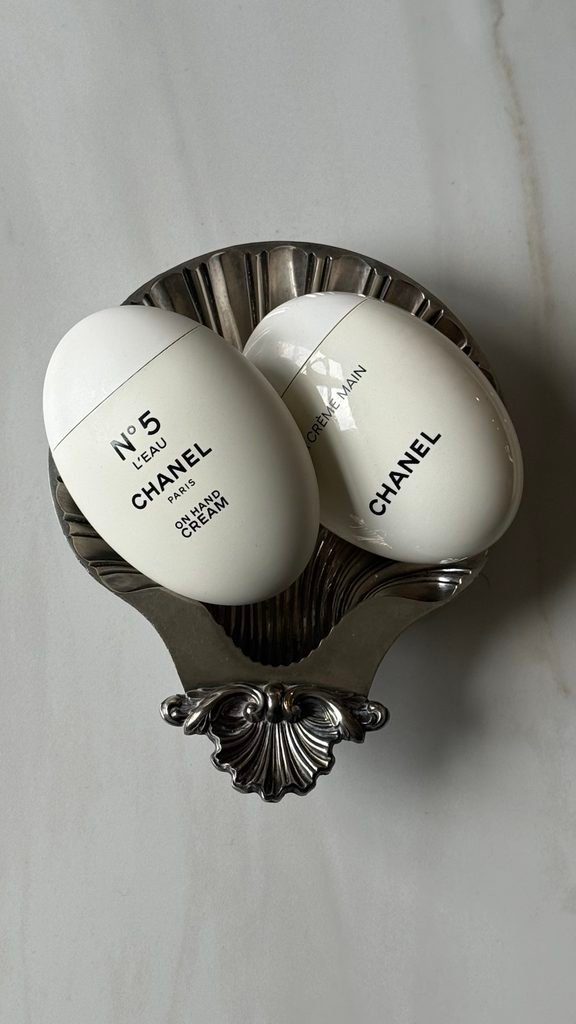 Two Chanel No. 5 hand creams arranged in a vintage silver shell dish.